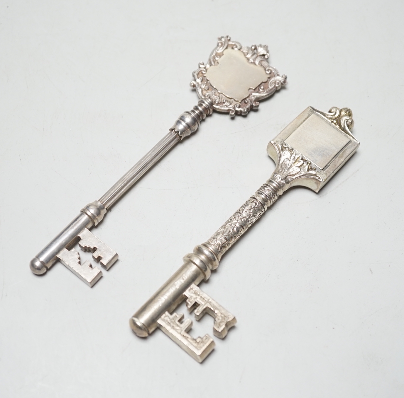 A late Victorian silver presentation key, with engraved armorial, James Fenton & Co, Birmingham, 1897, 16.9cm, 3.2oz and a similar silver plated key.